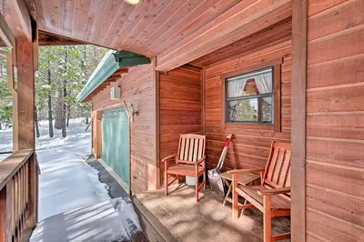 a cabin with two chairs and a table on a porch at Near Bear Valley Peaceful Arnold Home with Hot Tub in Arnold