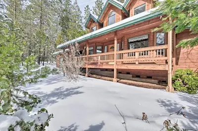 a log home with a deck in the snow at Near Bear Valley Peaceful Arnold Home with Hot Tub in Arnold