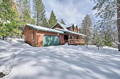 a log cabin in the snow in the woods at Near Bear Valley Peaceful Arnold Home with Hot Tub in Arnold