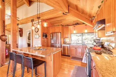 a kitchen with wooden cabinets and a large island at 1 Mi to Lake Tahoe Home with Hot Tub and Decks in Tahoe City