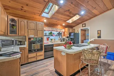 a large kitchen with wooden cabinets and a kitchen island at 11 Mi to Apple Hill Pollock Pines Resort Cabin in Pollock Pines