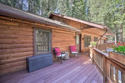 a cabin with two chairs and a table on a deck at 11 Mi to Apple Hill Pollock Pines Resort Cabin in Pollock Pines