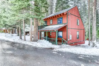 a red house in the woods with snow on the ground at Charming Mountain Chalet in Truckee