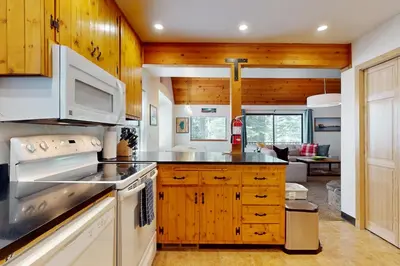 a kitchen with white appliances and wooden cabinets at Charming Mountain Chalet in Truckee