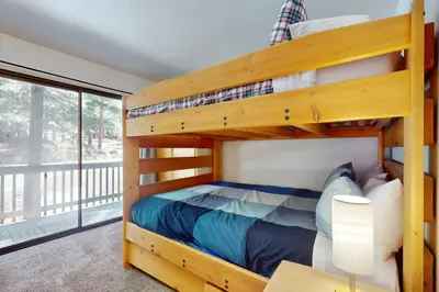 a bedroom with two bunk beds and a balcony at Charming Mountain Chalet in Truckee