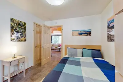 a bedroom with a bed and a desk and a window at Charming Mountain Chalet in Truckee