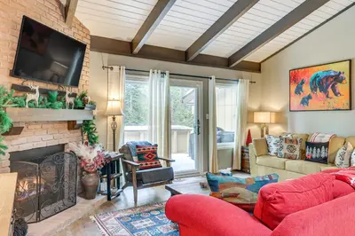 a living room with a red couch and a fireplace at 1 Mi to Diamond Peak Ski Resort Forest-View Condo in Incline Village
