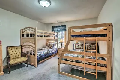 a bedroom with two bunk beds and a chair at Carnelian Bay Home with Hot Tub Near Tahoe Skiing in Carnelian Bay
