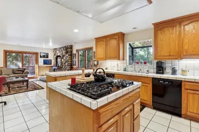 a kitchen with wooden cabinets and a stove top oven at Lake Tahoe Family Home with Hot Tub and Game Room! in Incline Village