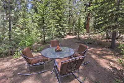 a table with four chairs sitting around it in the woods at Lake Tahoe Family Home with Hot Tub and Game Room! in Incline Village