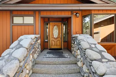 a front door of a home with a stone wall at Lake Tahoe Family Home with Hot Tub and Game Room! in Incline Village