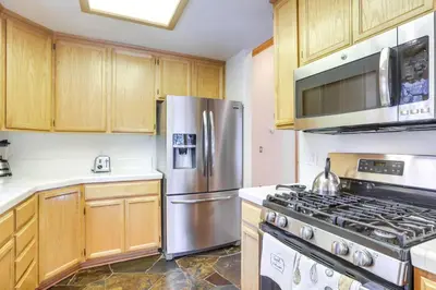 a kitchen with wooden cabinets and a stainless steel refrigerator at 7 Mi to Northstar Resort Tahoe Vista Family Cabin in Tahoe Vista