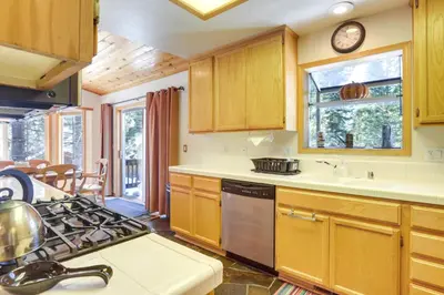a kitchen with wooden cabinets and a stove top oven at 7 Mi to Northstar Resort Tahoe Vista Family Cabin in Tahoe Vista