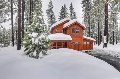 a wooden cabin in the woods in the snow at 4 Mi to Skiing Truckee Escape with Deck in Truckee