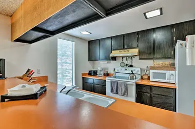 a kitchen with wooden cabinets and a white refrigerator at Ski Condo with Beach Access and 2 Mi to Diamond Peak! in Incline Village