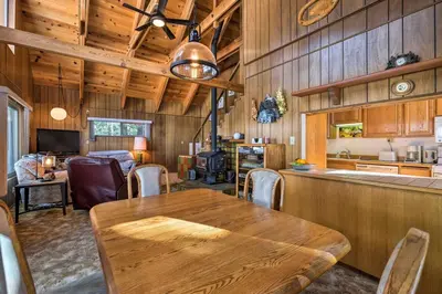 a dining room and kitchen with a wooden table and chairs at Near Hiking and Skiing Bear Valley Cabin! in Tamarack