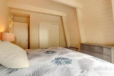 a bedroom with a bed with a blue and white blanket at Near Skiing and Hiking Carnelian Bay Cabin in Carnelian Bay