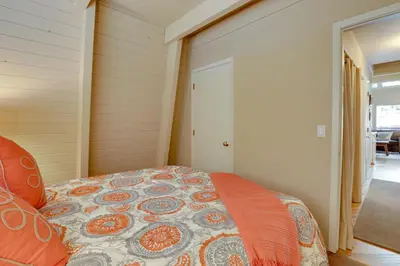 a bedroom with a bed with an orange comforter at Near Skiing and Hiking Carnelian Bay Cabin in Carnelian Bay