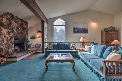 a living room with a blue couch and a fireplace at Spacious and Cozy Condo, 1 Block To The Village in Mammoth Lakes