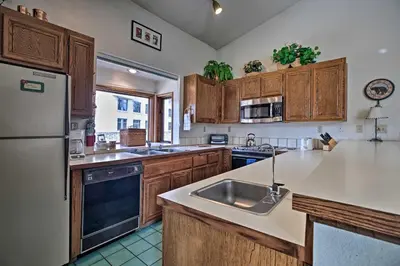 a kitchen with wooden cabinets and a stainless steel refrigerator at Spacious and Cozy Condo, 1 Block To The Village in Mammoth Lakes