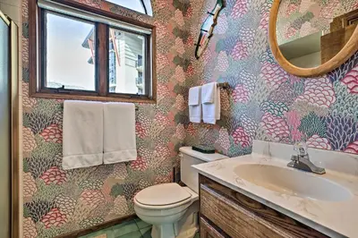 a bathroom with a toilet and a sink and a mirror at Spacious and Cozy Condo, 1 Block To The Village in Mammoth Lakes