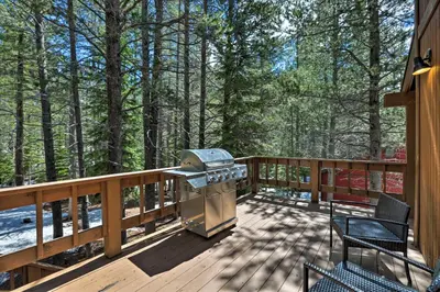 a grill on a deck with trees in the background at Cabin with Hot Tub and BBQ Deck Less Than 4 Mi to Donner Lake! in Truckee
