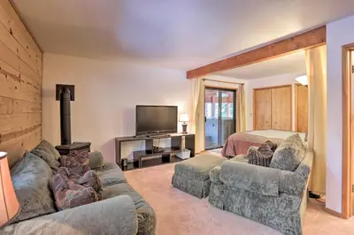 a living room with a couch and a tv and a bed at Cabin with Hot Tub and BBQ Deck Less Than 4 Mi to Donner Lake! in Truckee