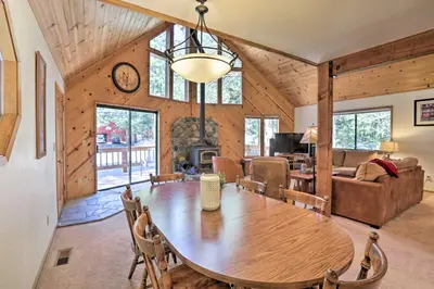 a dining room and living room with a wooden table at Cabin with Hot Tub and BBQ Deck Less Than 4 Mi to Donner Lake! in Truckee