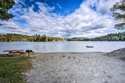 a picnic table and a boat on a lake at Mountain Paradise about 1 Mile to Pine Mountain Lake! in Groveland