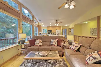 a living room with two couches and a table at Walk to Big Trees State Park Cabin with Deck! in Dorrington