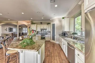 a large kitchen with white cabinets and a large island at Near Wineries Elk Grove Getaway with Saltwater Pool in Elk Grove