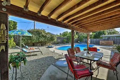 a patio with a table and chairs and a pool at Updated Sacramento Home with Grill, Patio, and Pool! in Sacramento
