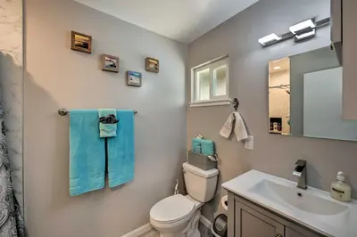 a bathroom with a toilet and a sink and a mirror at Updated Sacramento Home with Grill, Patio, and Pool! in Sacramento