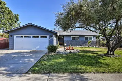 a house with a white garage and a tree at Updated Sacramento Home with Grill, Patio, and Pool! in Sacramento