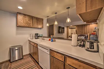 a kitchen with a white counter top and wooden cabinets at Mammoth Lakes Condo, Walk to Shuttle and Village in Mammoth Lakes
