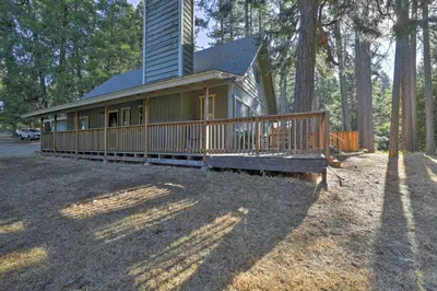 a small house with a large deck in the woods at Cabin in Natl Forest 35 Min to Boreal Resort in Colfax