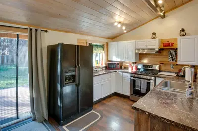a kitchen with a black refrigerator and white cabinets at 3 Mi to Heavenly Mountain Resort Home with Deck in Stateline