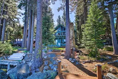 a house in the woods with trees and benches at Hot Tub and Lake Tahoe Views Waterfront Retreat in Tahoma