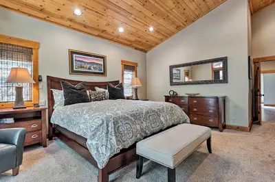 a bedroom with a bed and a mirror and a chair at Truckee Escape with Hot Tub Near Ski Resorts in Truckee