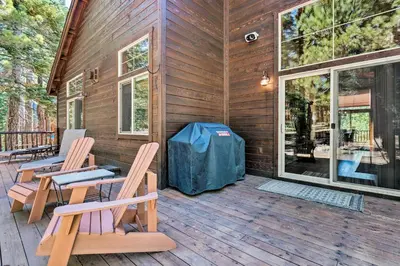 a cabin with two chairs on a wooden deck at Truckee Escape with Hot Tub Near Ski Resorts in Truckee