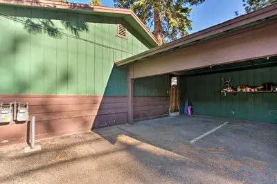 a green building with a large garage with at Home 1 Mi to Heavenly Mtn Resort! Unwind Fireside in South Lake Tahoe