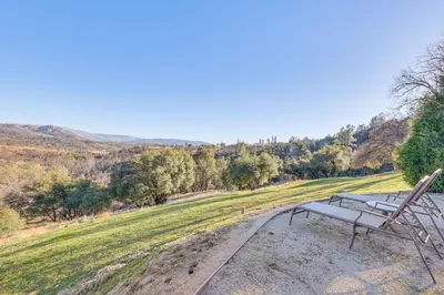 a bench sitting on the side of a field at 28 Mi to Yosemite Lovely Mtn Cottage with Deck! in North Fork