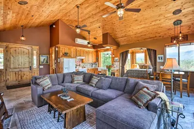 a living room with a couch and a table at 28 Mi to Yosemite Lovely Mtn Cottage with Deck! in North Fork