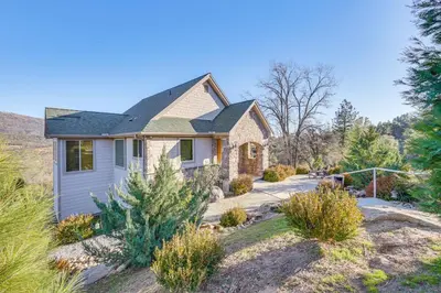 a house with a landscaping in front of it at 28 Mi to Yosemite Lovely Mtn Cottage with Deck! in North Fork