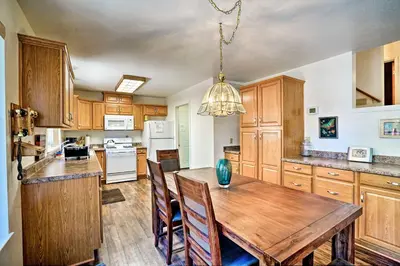 a kitchen with wooden cabinets and a wooden table at 4 Mi to Heavenly Home with Deck in South Lake Tahoe in South Lake Tahoe
