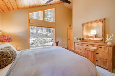 a bedroom with a large bed and a window at Tahoe Donner Mountain Cabin Surrounded by Forest! in Truckee