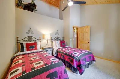 a bedroom with two beds and a wooden door at Tahoe Donner Mountain Cabin Surrounded by Forest! in Truckee