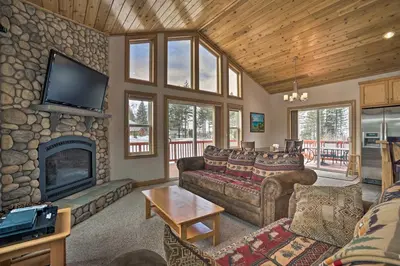 a living room with couches and a stone fireplace at 9 Mi to Heavenly Mountain South Lake Tahoe Home! in South Lake Tahoe