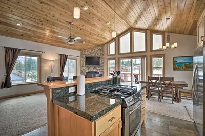 a kitchen with a stove and a living room at 9 Mi to Heavenly Mountain South Lake Tahoe Home! in South Lake Tahoe