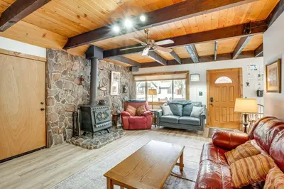a living room with a fireplace and a stone wall at 11 Mi to Ski Resorts! Lake Tahoe Gem with Pool Table in South Lake Tahoe